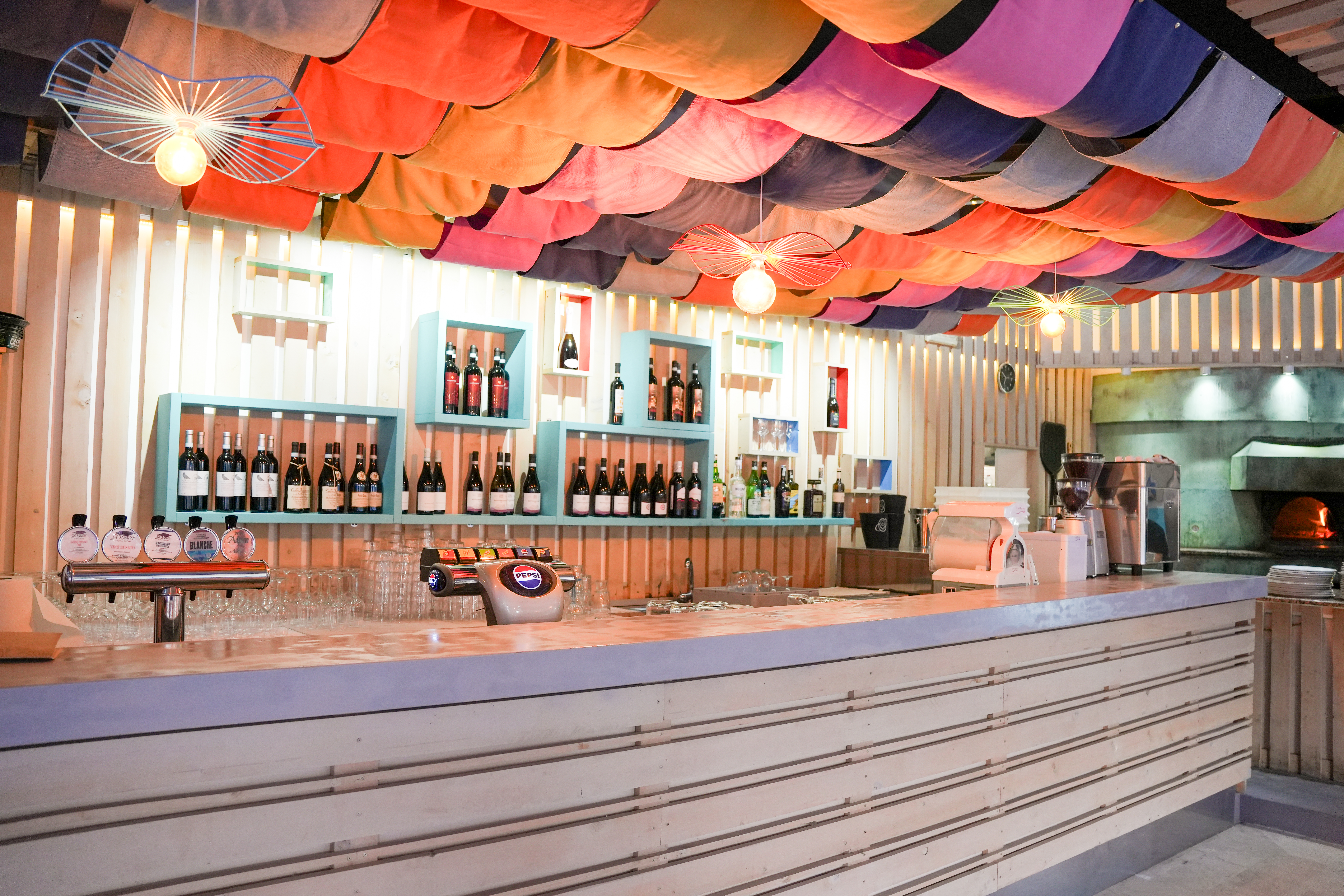 Il bancone bar de L'Oasi con cantina dei vini e forno a legna